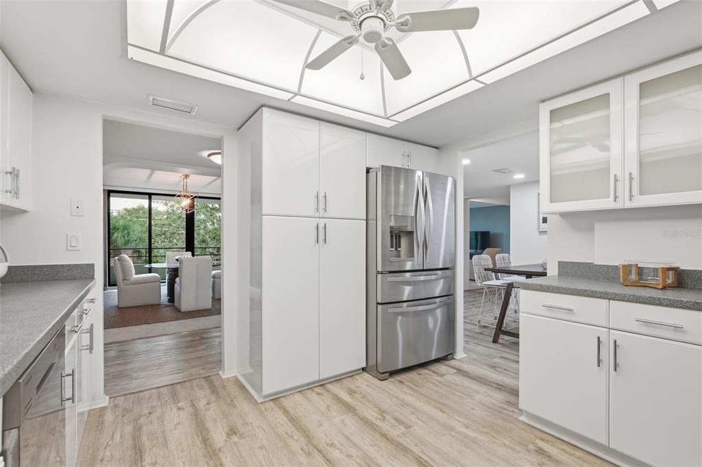 6415 Midnight Pass Road, Unit 211 Sarasota, FL 34242 - Photo 20 of 58 a kitchen with a refrigerator a sink and dishwasher with wooden floor