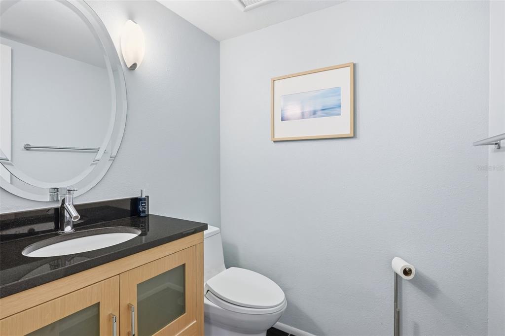 6415 Midnight Pass Road, Unit 211 Sarasota, FL 34242 - Photo 21 of 58 a bathroom with a toilet a sink and mirror