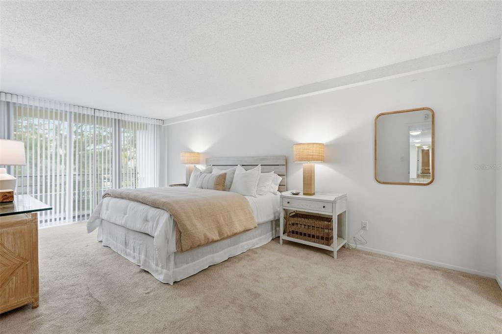 6415 Midnight Pass Road, Unit 211 Sarasota, FL 34242 - Photo 23 of 58 a bedroom with a bed lamp on desk and a window