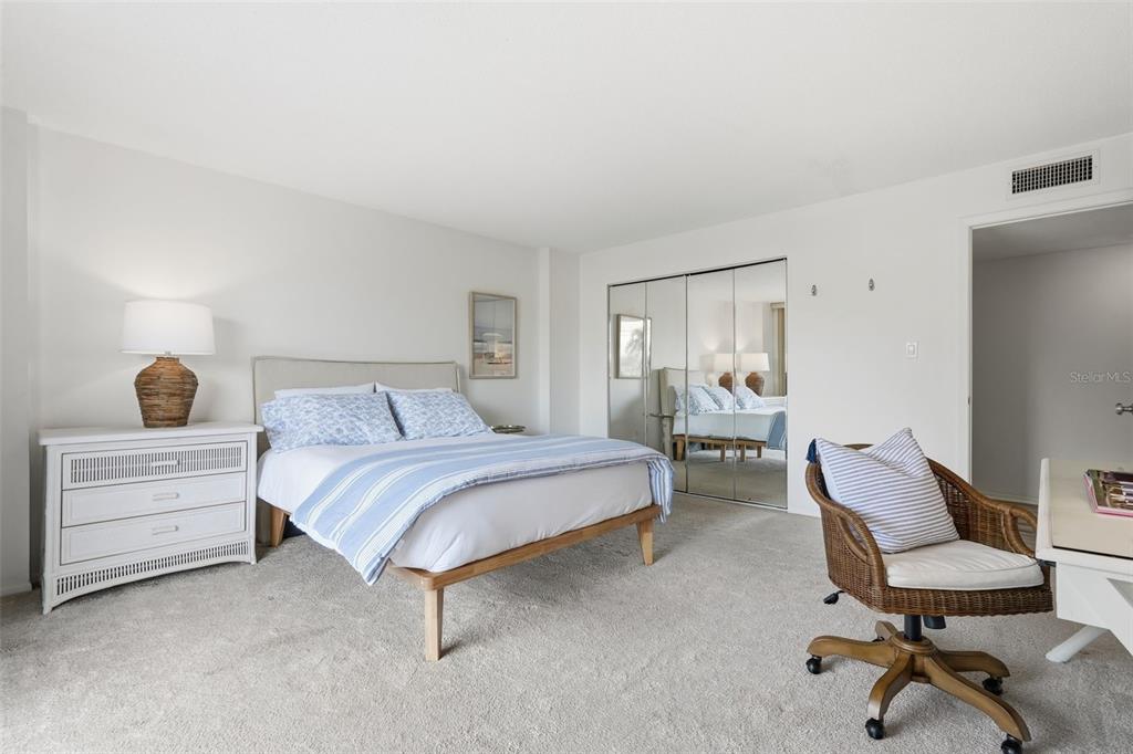 6415 Midnight Pass Road, Unit 211 Sarasota, FL 34242 - Photo 30 of 58 a bedroom with a bed and a chair