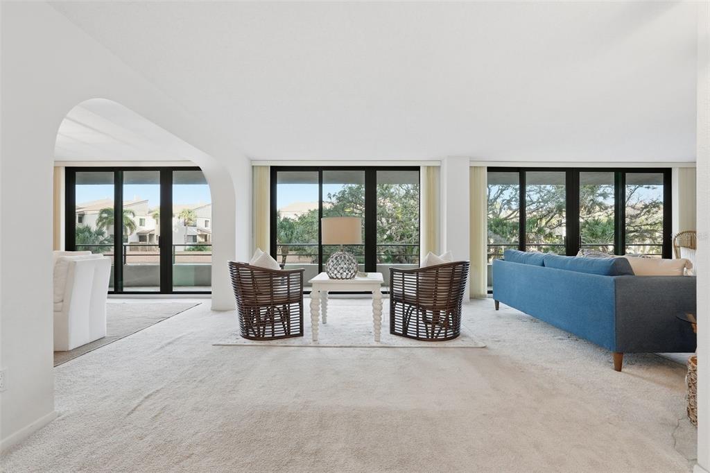 6415 Midnight Pass Road, Unit 211 Sarasota, FL 34242 - Photo 7 of 58 a living room with furniture and large windows