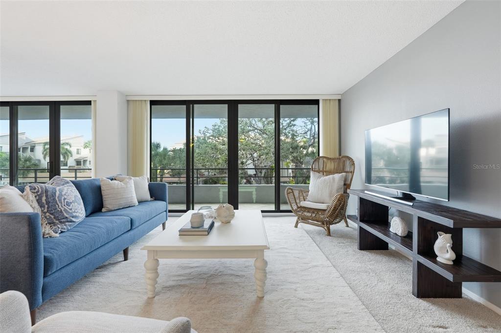 6415 Midnight Pass Road, Unit 211 Sarasota, FL 34242 - Photo 8 of 58 a living room with furniture and large windows