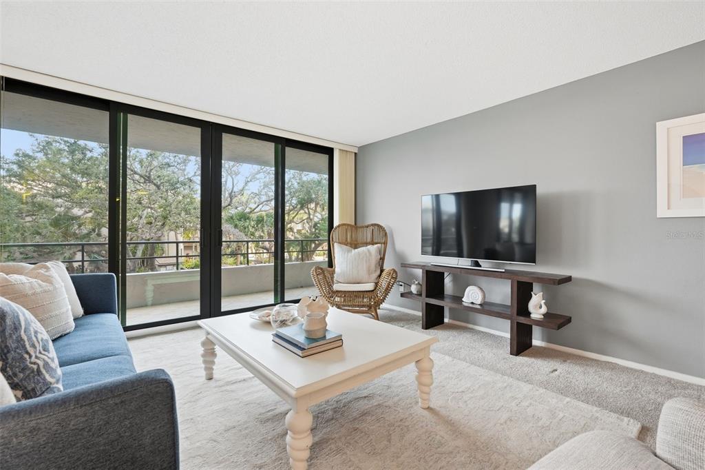 6415 Midnight Pass Road, Unit 211 Sarasota, FL 34242 - Photo 9 of 58 a living room with furniture and a flat screen tv