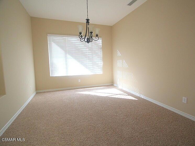276 Chantilly Circle Simi Valley, CA 93065 - Photo 4 of 25 an empty room with a chandelier fan and windows