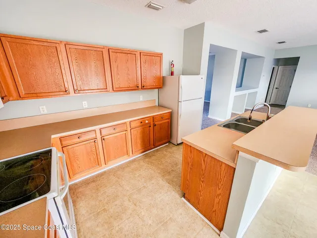 a kitchen with stainless steel appliances a stove a sink and a refrigerator with wooden floor