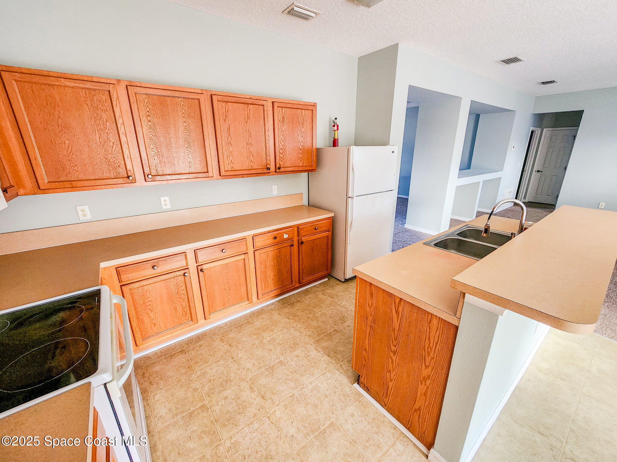 1421 Halstead Avenue Northwest Palm Bay, FL 32907 - Photo 12 of 22 a kitchen with stainless steel appliances a stove a sink and a refrigerator with wooden floor