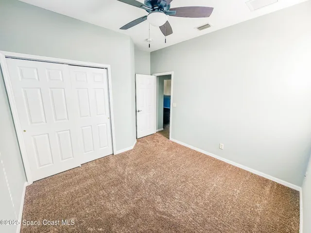 an empty room with a ceiling fan and a window