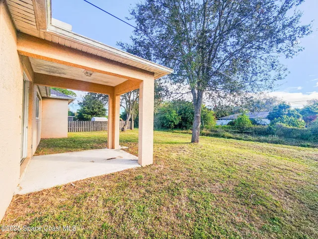 a view of a house with backyard and porch