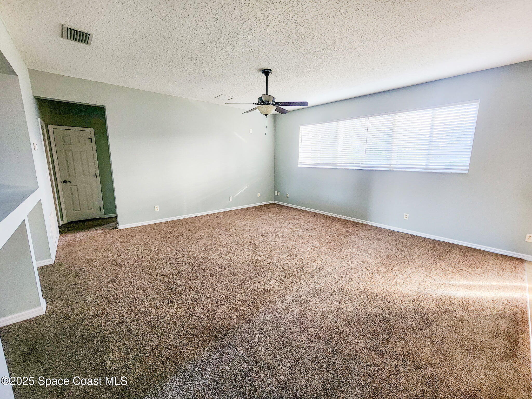 1421 Halstead Avenue Northwest Palm Bay, FL 32907 - Photo 8 of 22 an empty room with windows and fan