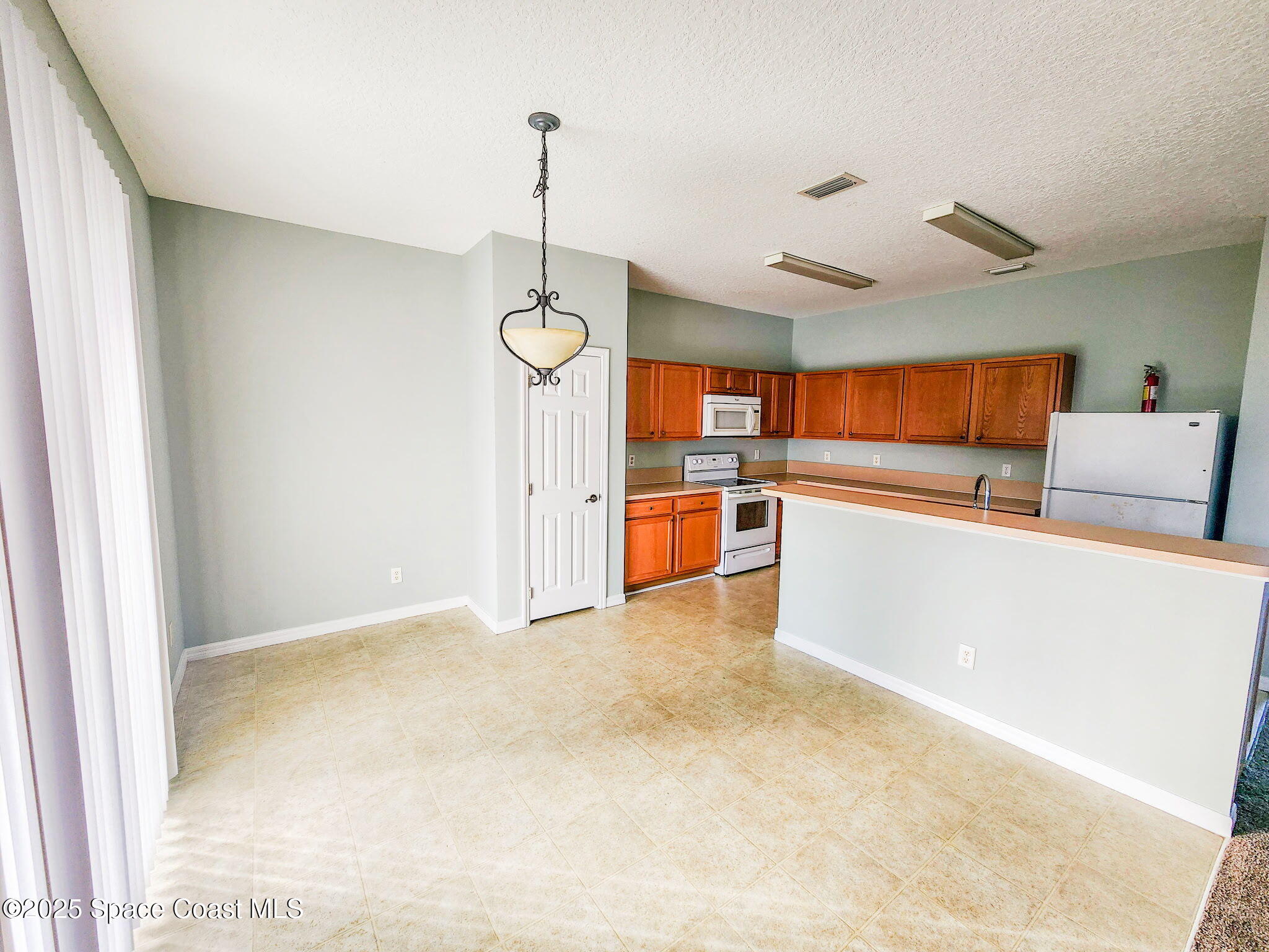 1421 Halstead Avenue Northwest Palm Bay, FL 32907 - Photo 10 of 22 a view of a kitchen with a refrigerator and microwave