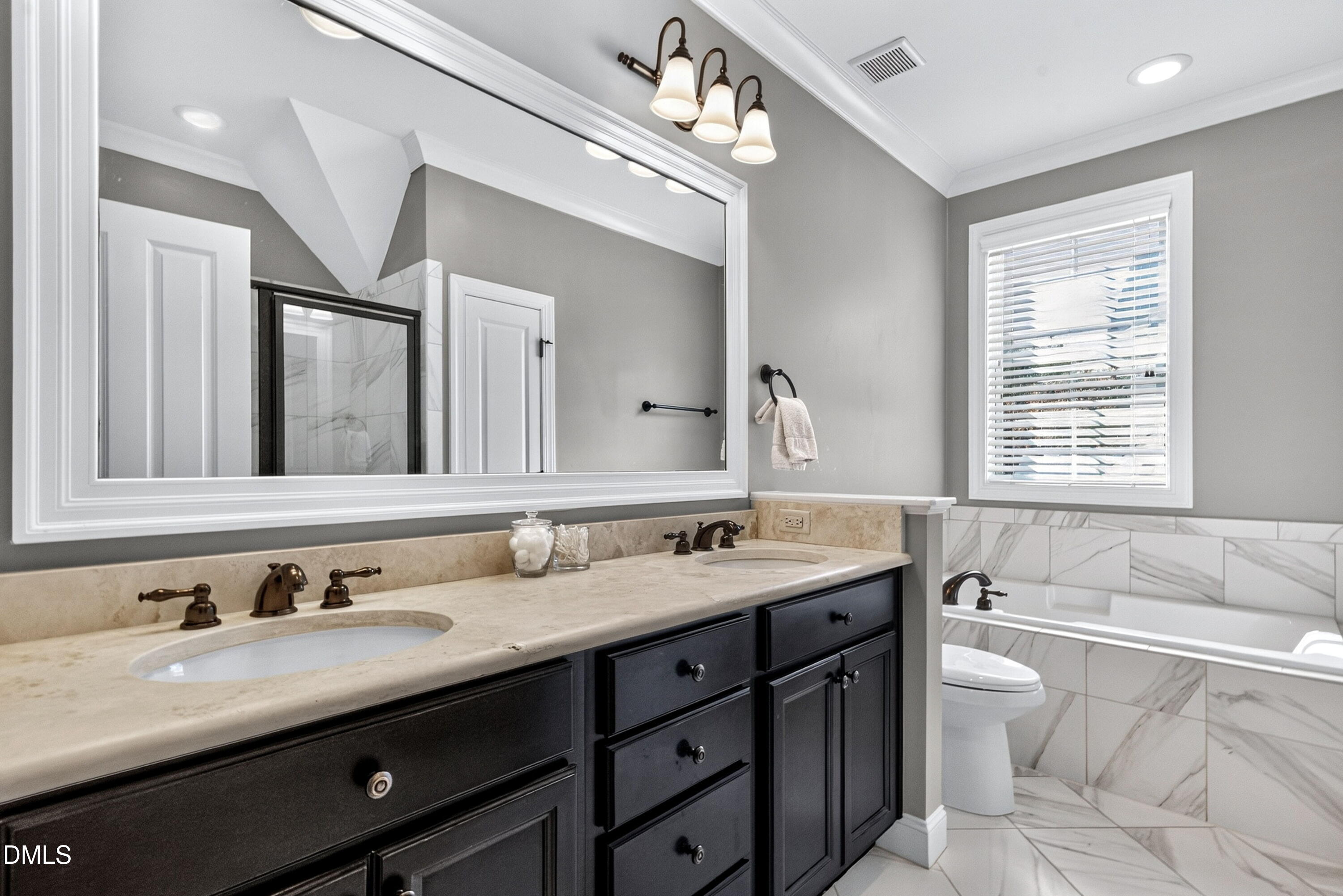 2745 Oberlin Road, Unit 103 Raleigh, NC 27608 - Photo 7 of 23 a bathroom with double vanity sinks a large mirror and a bathtub