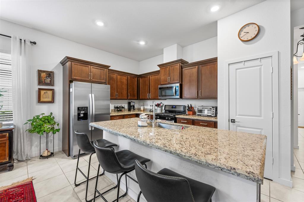 19707 Weathervane Way Loxahatchee, FL 33470 - Photo 22 of 51 a kitchen with granite countertop a table chairs stove refrigerator and microwave
