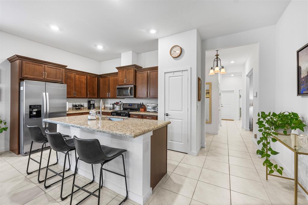 19707 Weathervane Way Loxahatchee, FL 33470 - Photo 25 of 51 a kitchen with stainless steel appliances kitchen island granite countertop a refrigerator and a stove top oven