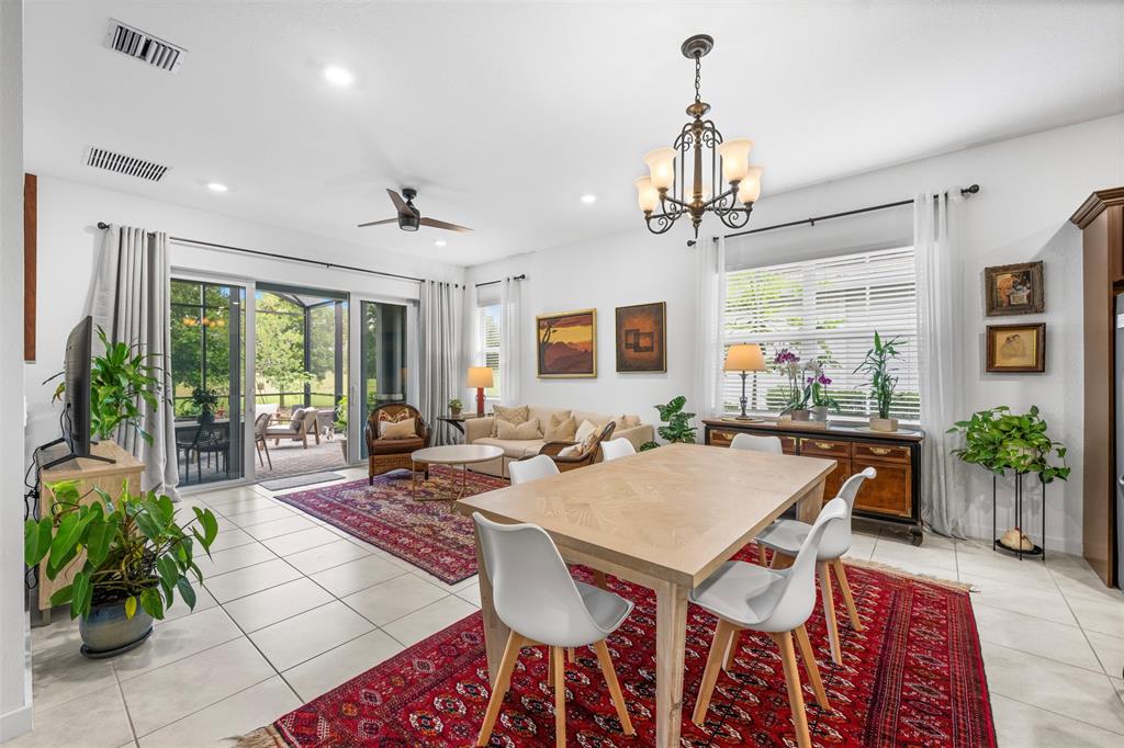19707 Weathervane Way Loxahatchee, FL 33470 - Photo 4 of 51 a view of a dining room and livingroom with furniture wooden floor a chandelier and a rug