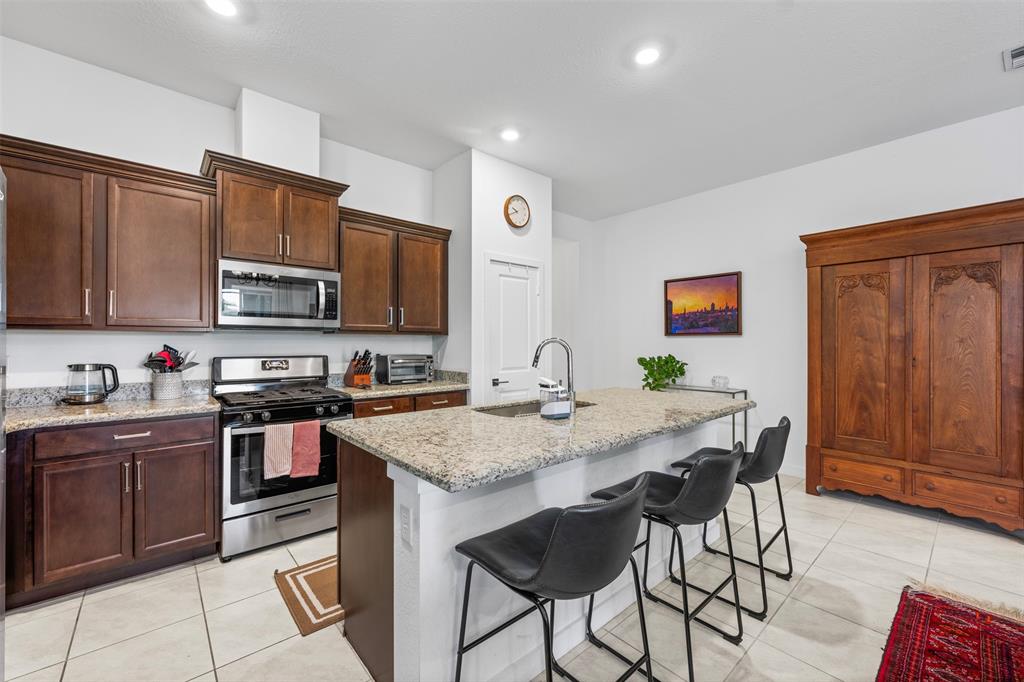 19707 Weathervane Way Loxahatchee, FL 33470 - Photo 5 of 51 a kitchen with stainless steel appliances granite countertop a stove a sink dishwasher and a refrigerator with wooden cabinets