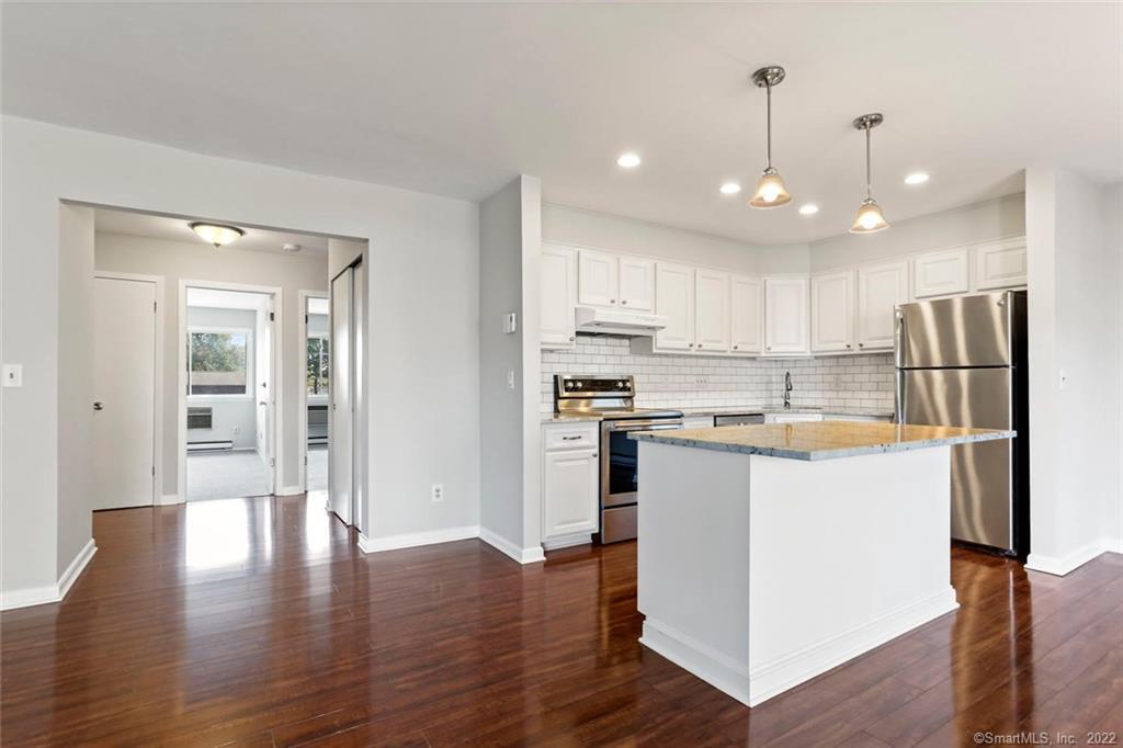 180 Colonial Road, Unit A3 Stamford, CT 06906 - Photo 1 of 1 a kitchen with stainless steel appliances granite countertop a refrigerator a sink a stove and white cabinets with wooden floor