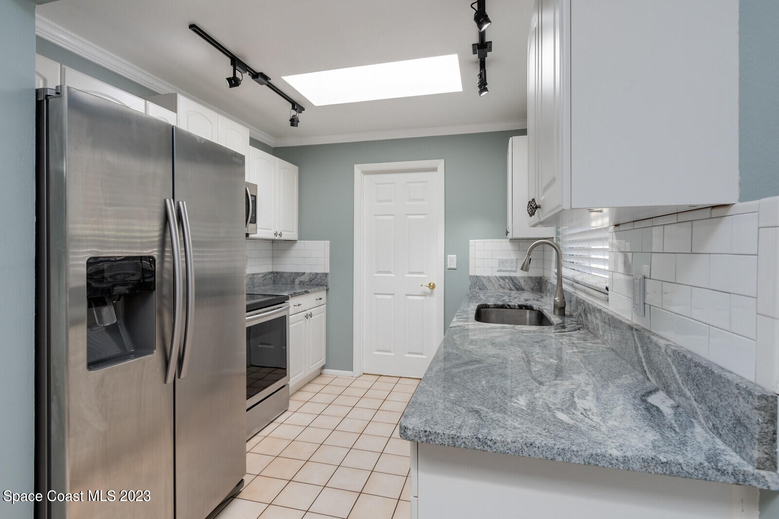 3229 Marshall Drive Melbourne, FL 32901 - Photo 10 of 36 a kitchen with a refrigerator sink and cabinets