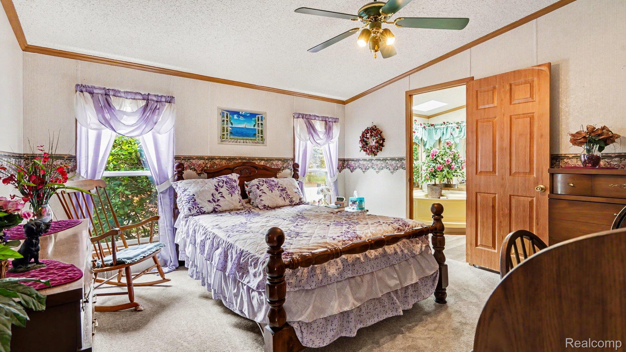 3115 Brogan Road Stockbridge, MI 49285 - Photo 13 of 30 Carpeted room featuring a ceiling fan, a window, and a paneled door