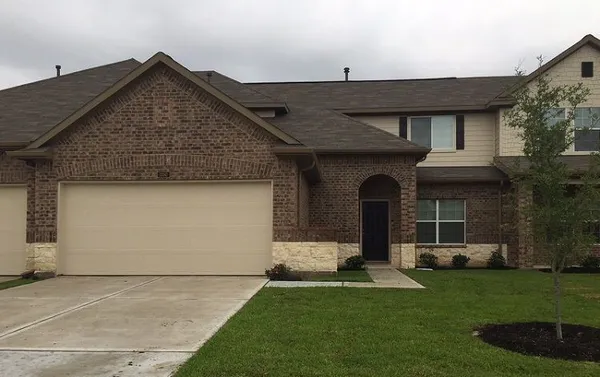 a front view of a house with a garden and plants