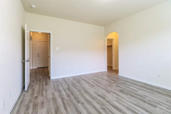 a view of a room with wooden floor and a ceiling fan