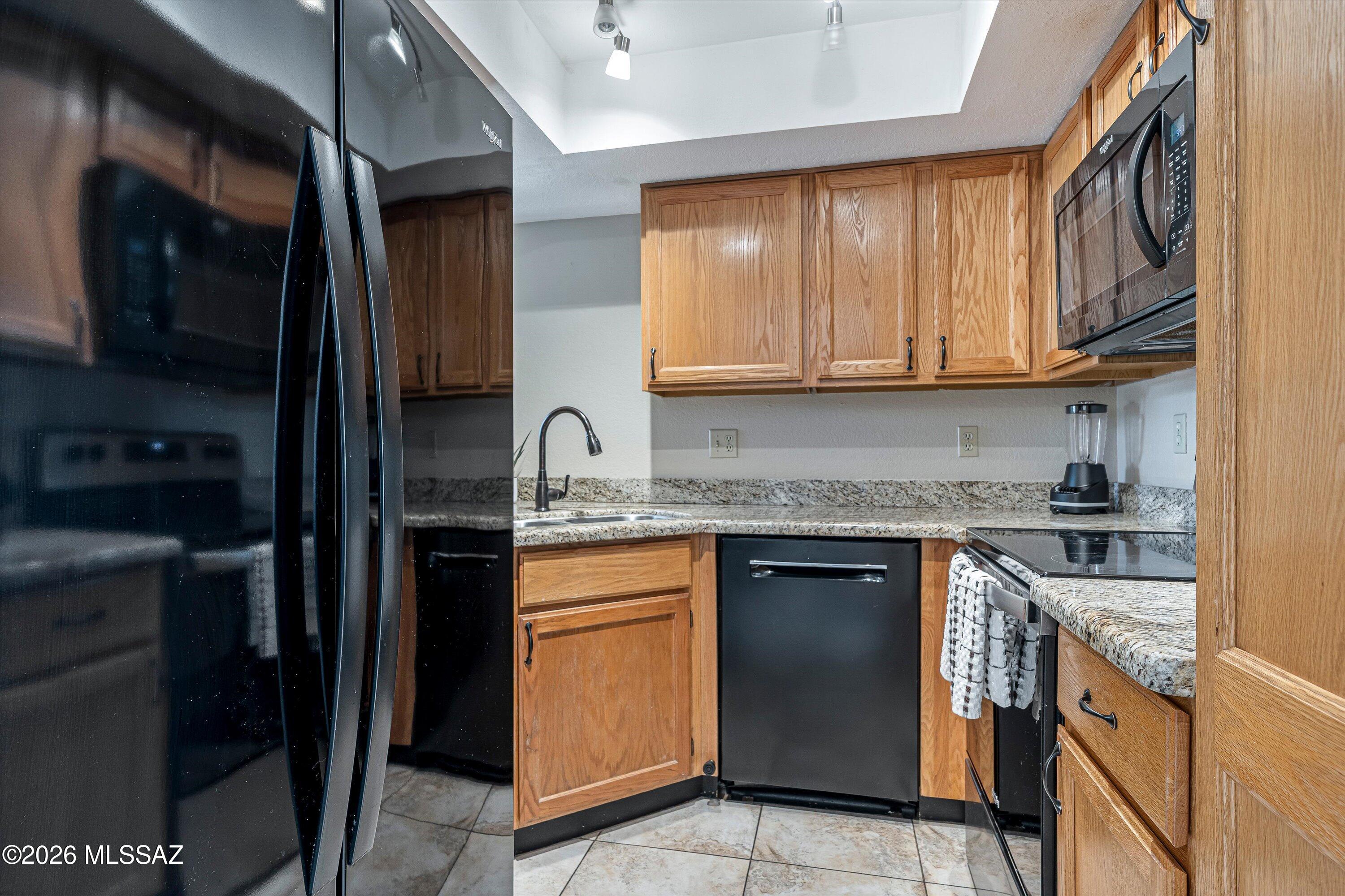 5800 North Kolb Road, Unit 5125 Tucson, AZ 85750 - Photo 9 of 34 a kitchen with stainless steel appliances granite countertop a stove sink and cabinets