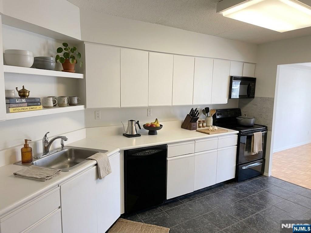 1055 River Road, Unit 1004 Edgewater, NJ 07020 - Photo 9 of 23 a kitchen with a sink dishwasher and cabinets