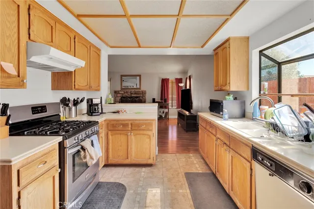 a kitchen with stainless steel appliances granite countertop a stove a sink and a refrigerator
