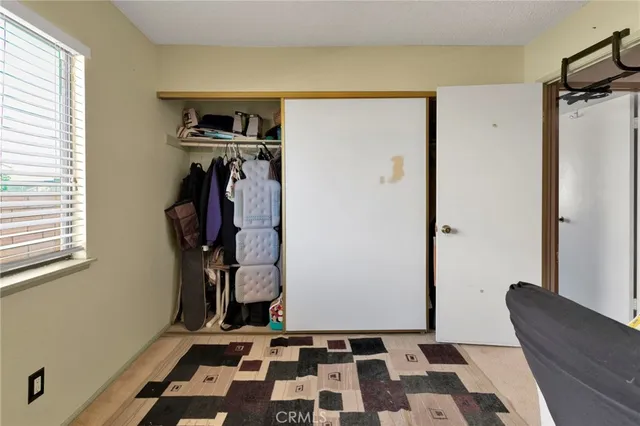 a walk in closet with wooden floor