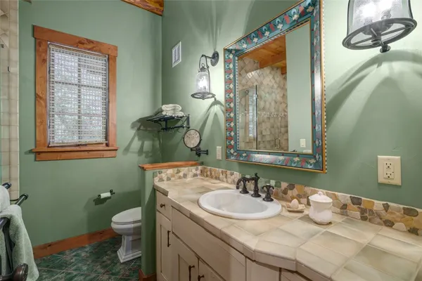 a bathroom with a granite countertop sink and a mirror