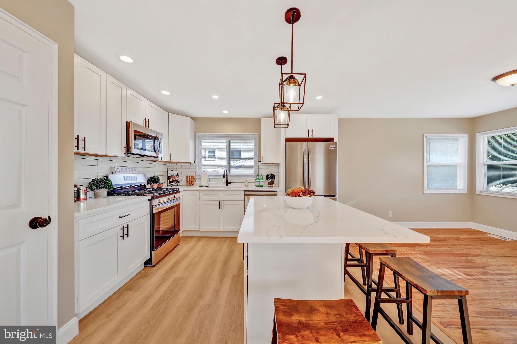 1538 Haddonfield-Berlin Road Cherry Hill, NJ 08003 - Photo 18 of 36 a kitchen with stainless steel appliances kitchen island granite countertop a refrigerator a stove and white cabinets with wooden floor