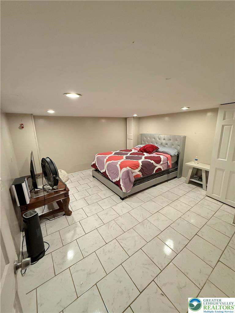 1025 Spring Street Bethlehem, PA 18018 - Photo 15 of 20 Recessed lighting illuminates a well-appointed bedroom with sleek tile flooring.