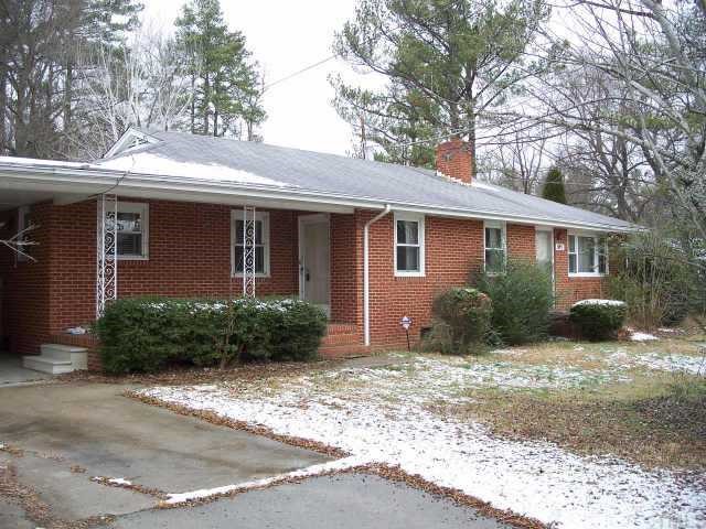 5713 North Roxboro Road Durham, NC 27712 - Photo 1 of 12 a front view of a house with a garden