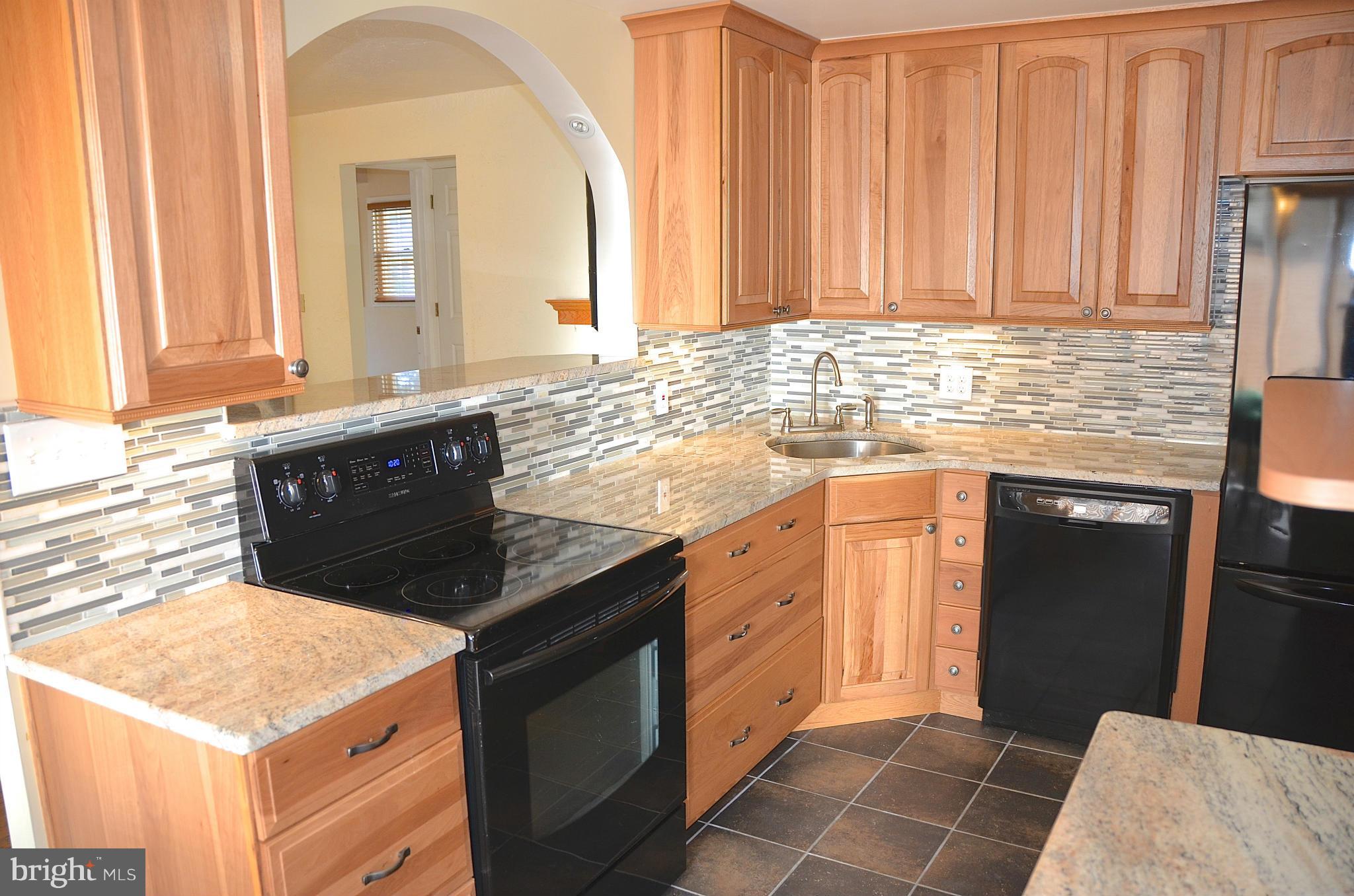 1607 Grange Road Edgewater, MD 21037 - Photo 5 of 30 a kitchen with granite countertop a sink a stove and cabinets