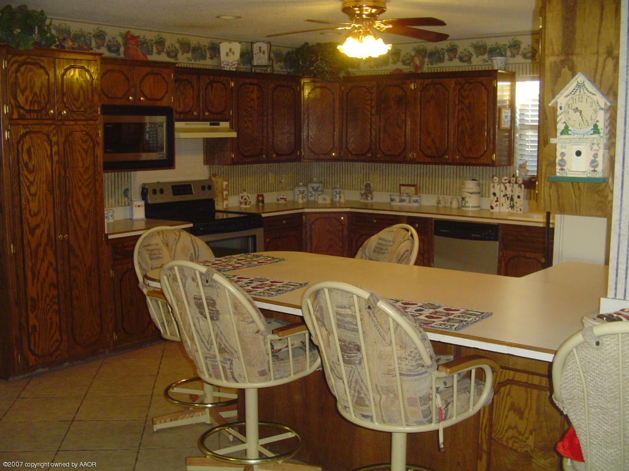 4202 Rondo Avenue Amarillo, TX 79110 - Photo 6 of 14 a kitchen with stainless steel appliances granite countertop a sink a microwave cabinets and chairs
