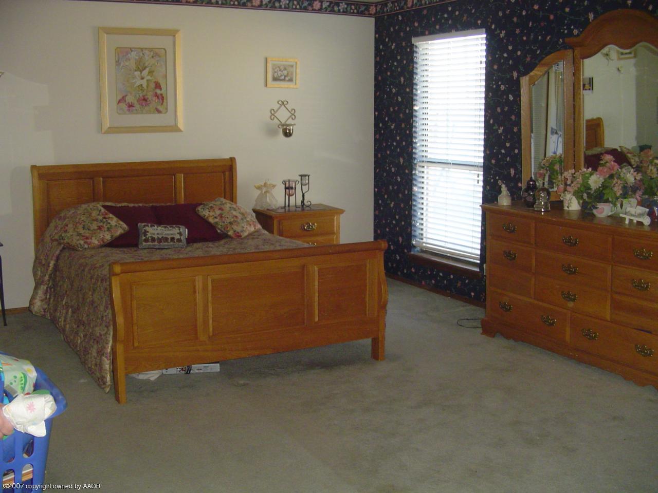 4202 Rondo Avenue Amarillo, TX 79110 - Photo 7 of 14 a bed sitting in a bedroom next to a window