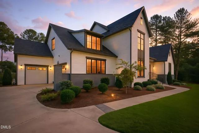 a front view of a house with a garden and plants