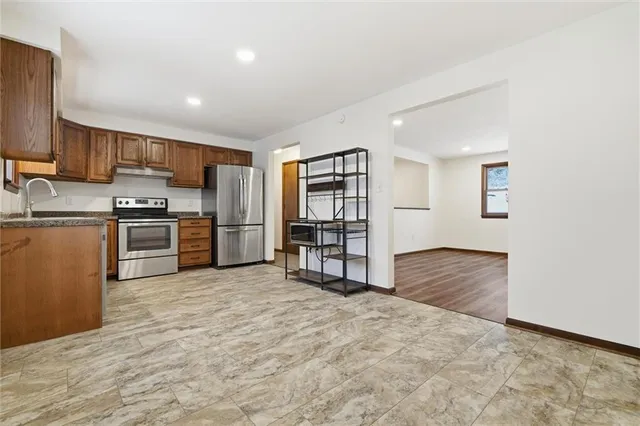 a kitchen with stainless steel appliances a refrigerator and a stove top oven