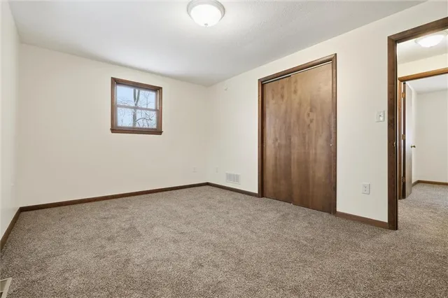 an empty room with a painting on the wall