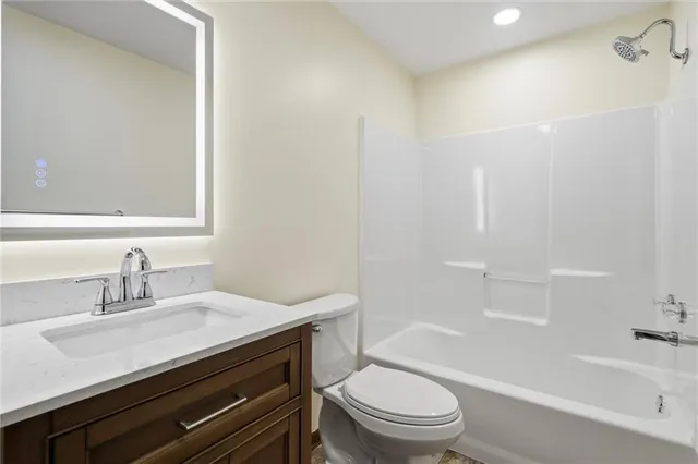 a bathroom with a toilet sink vanity and mirror
