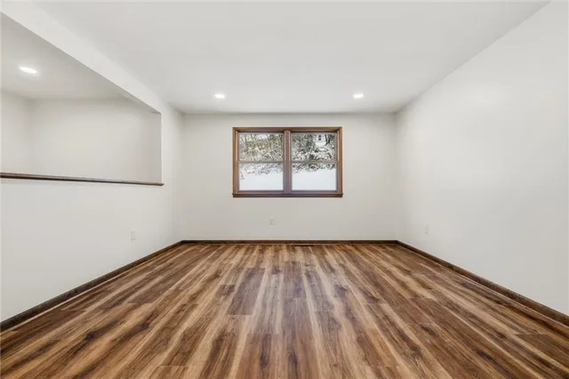 a view of a room with wooden floor and window
