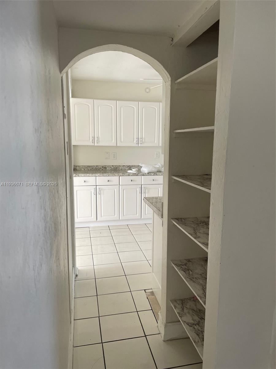 115 Virginia Road, Unit 115 Hollywood, FL 33023 - Photo 12 of 12 a view of a kitchen with white cabinets and a window