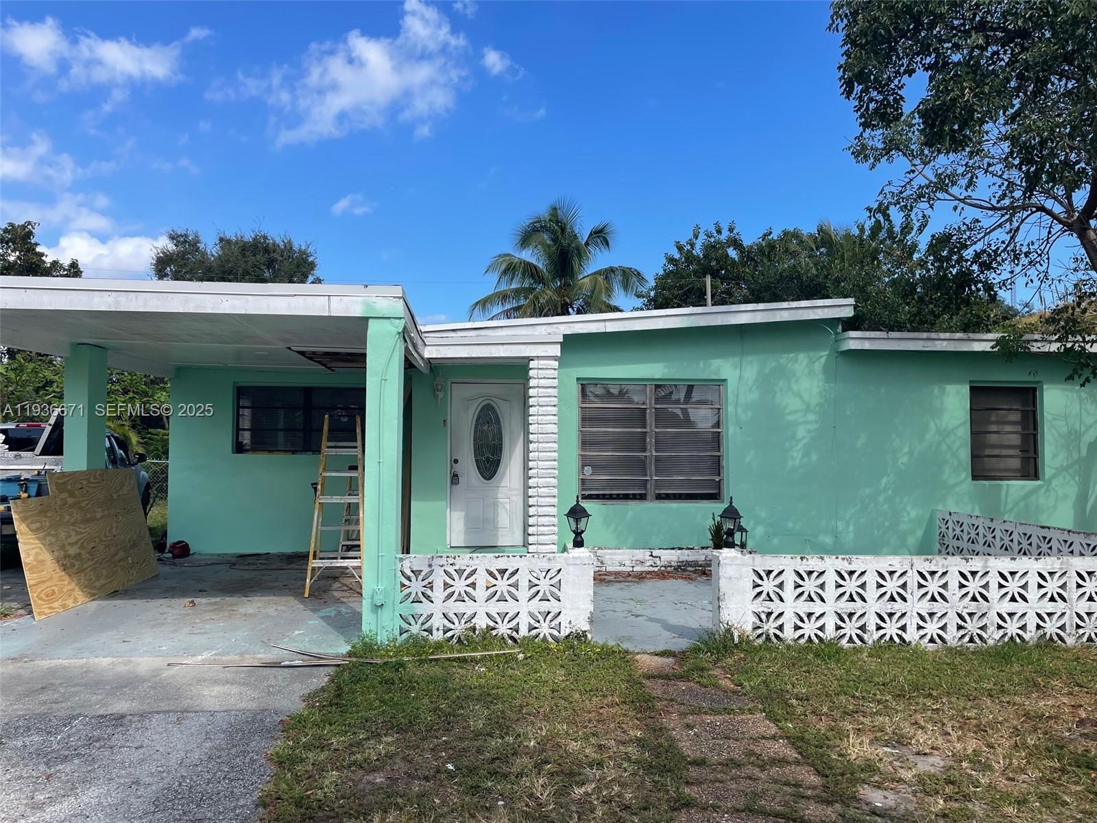 115 Virginia Road, Unit 115 Hollywood, FL 33023 - Photo 3 of 12 a front view of a house with a garden