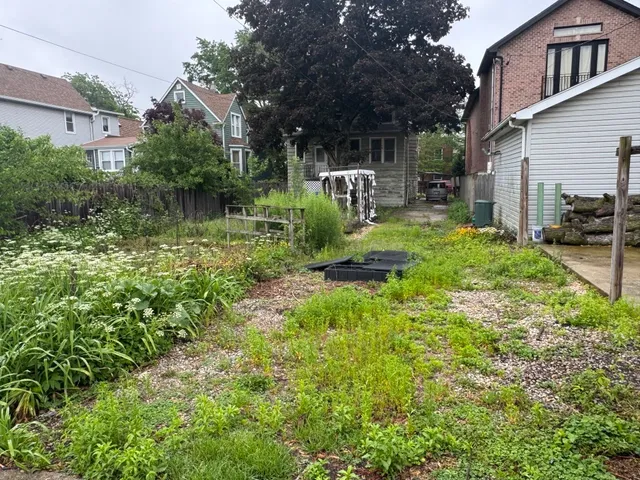 a view of backyard of house with outdoor seating and green space