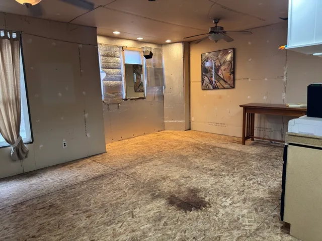a view of a livingroom with wooden floor and a refrigerator