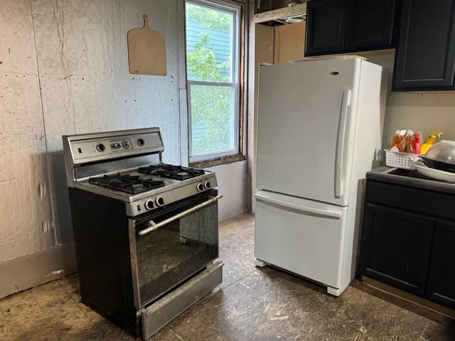 a white refrigerator freezer and a stove sitting inside of a kitchen