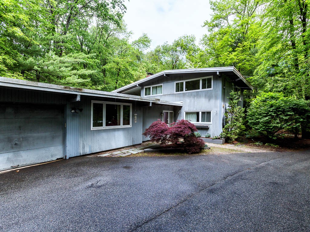 a view of a house with a yard and a large parking space