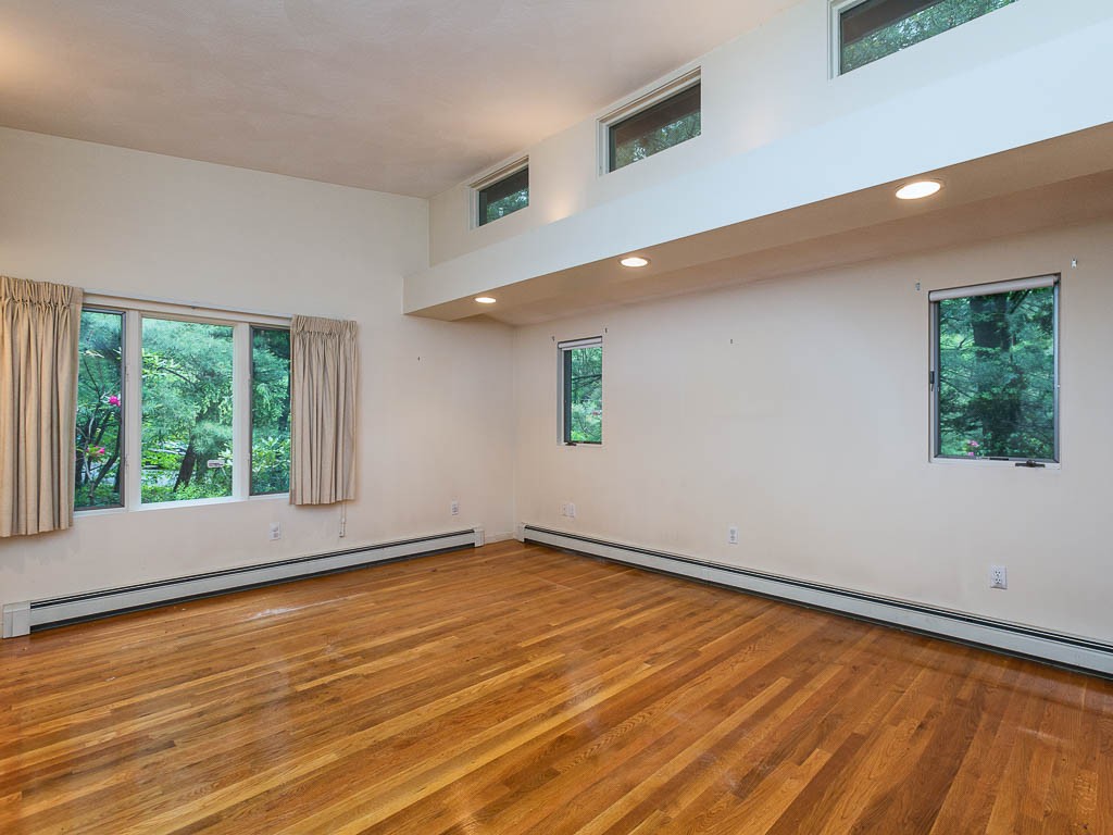 62 Turning Mill Road Lexington, MA 02420 - Photo 7 of 12 a view of an empty room with wooden floor and a window