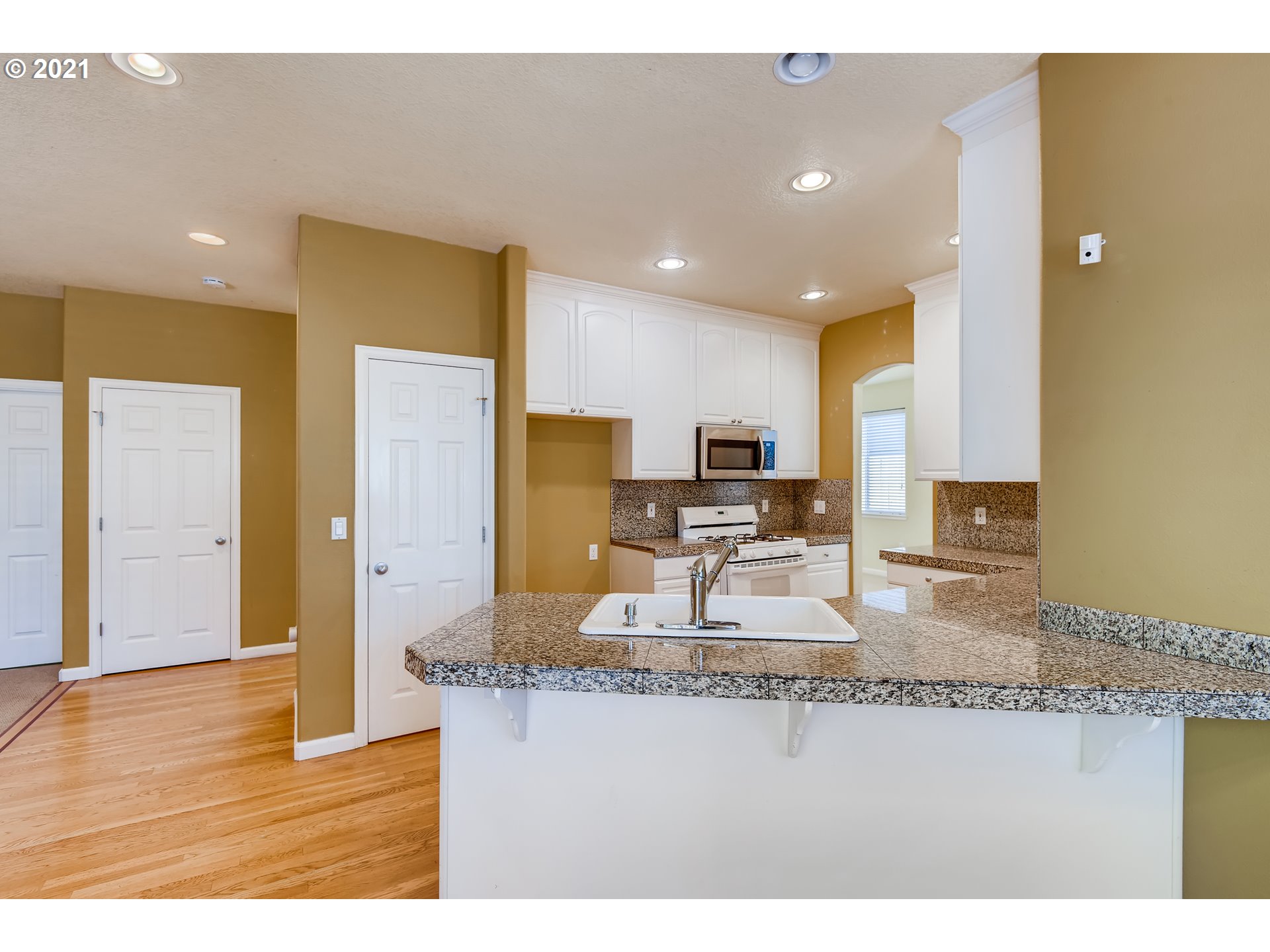 16123 Southeast Rural Court Portland, OR 97236 - Photo 8 of 32 a kitchen with kitchen island granite countertop a sink and a refrigerator