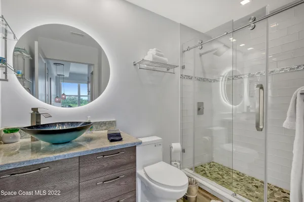 a bathroom with a toilet a sink and glass door