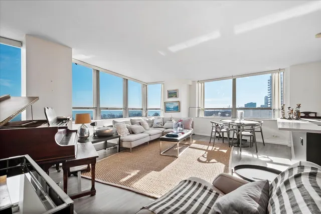 a living room with furniture kitchen view and large windows